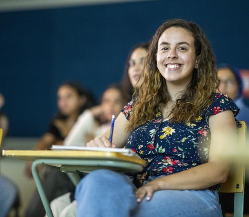 female student in class smiling to the camera