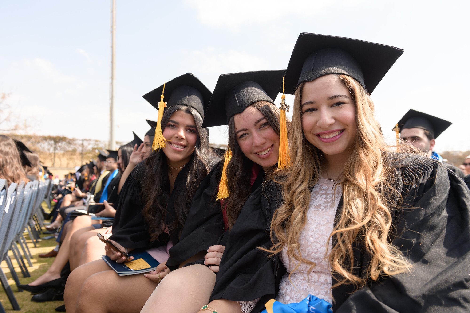 Students smiling with their cap and gown on graduation day