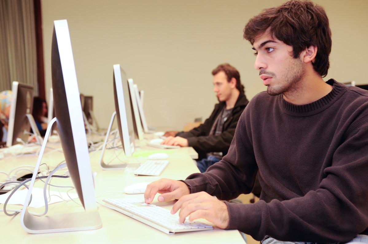 male student working on mac computer 