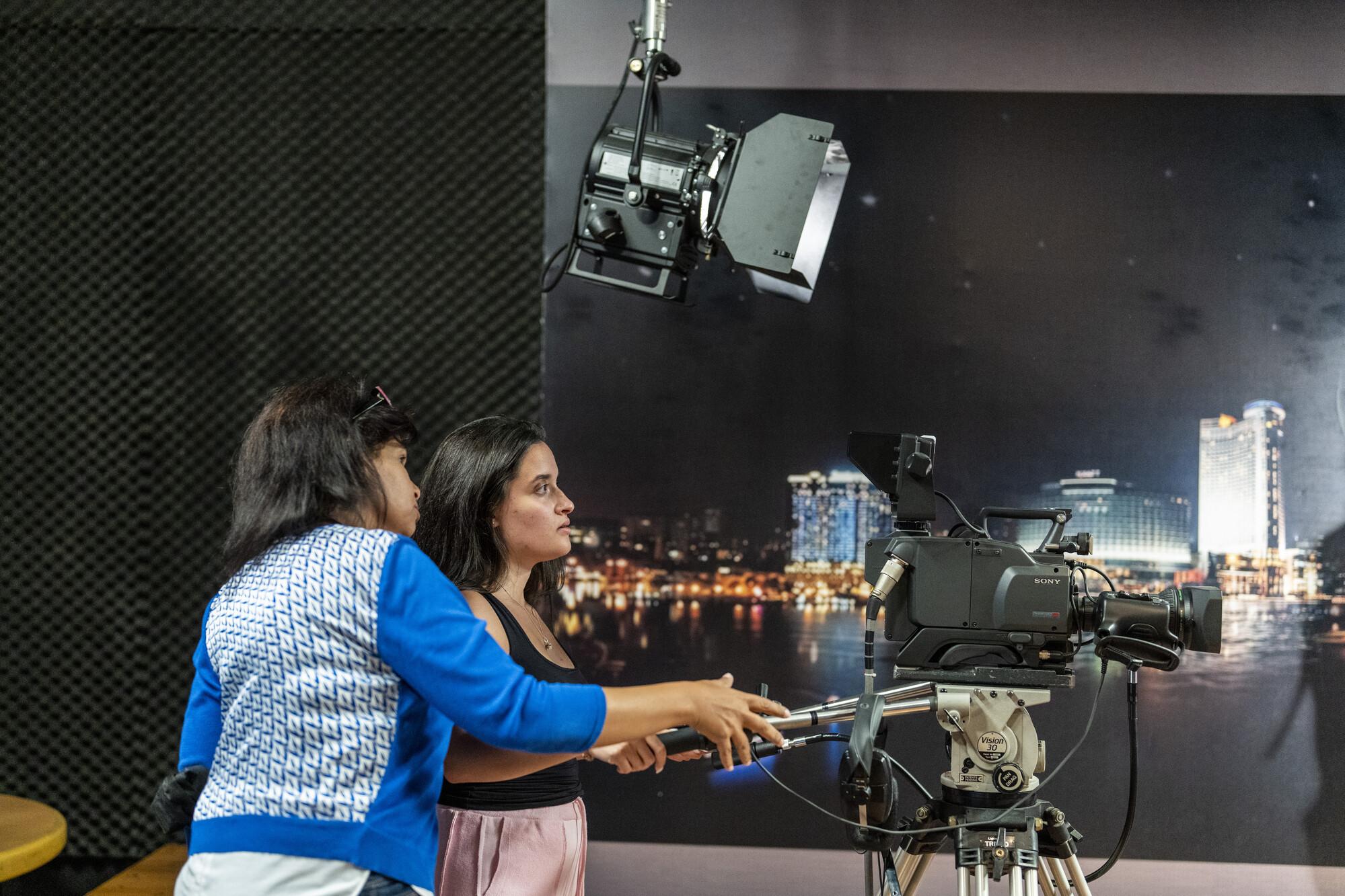 professor working with student in studio and how to work filming camera