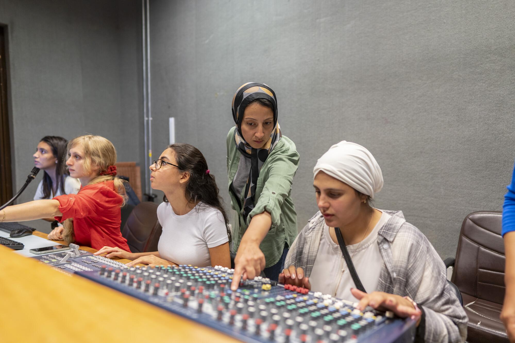 faculty showing students how to use studio equipment for filming 