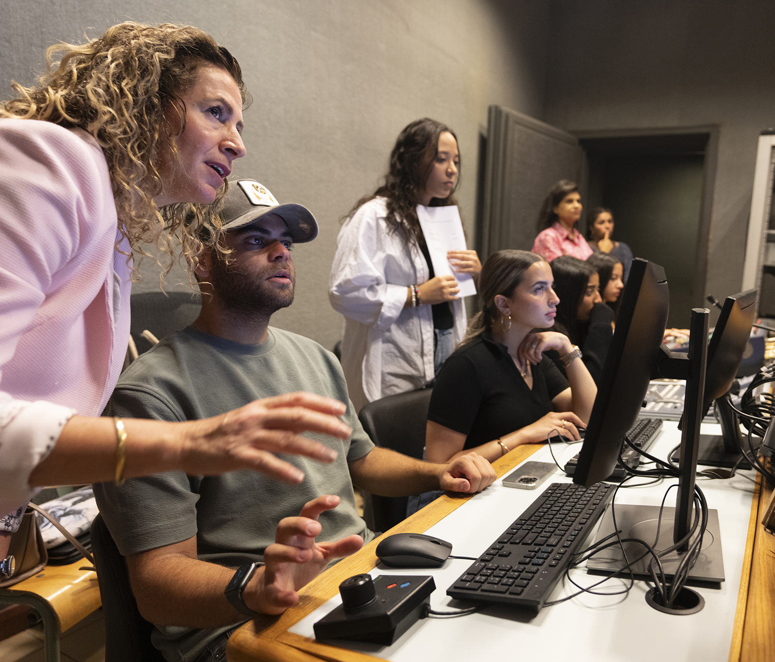 students using the equipment in studio with professor explaining