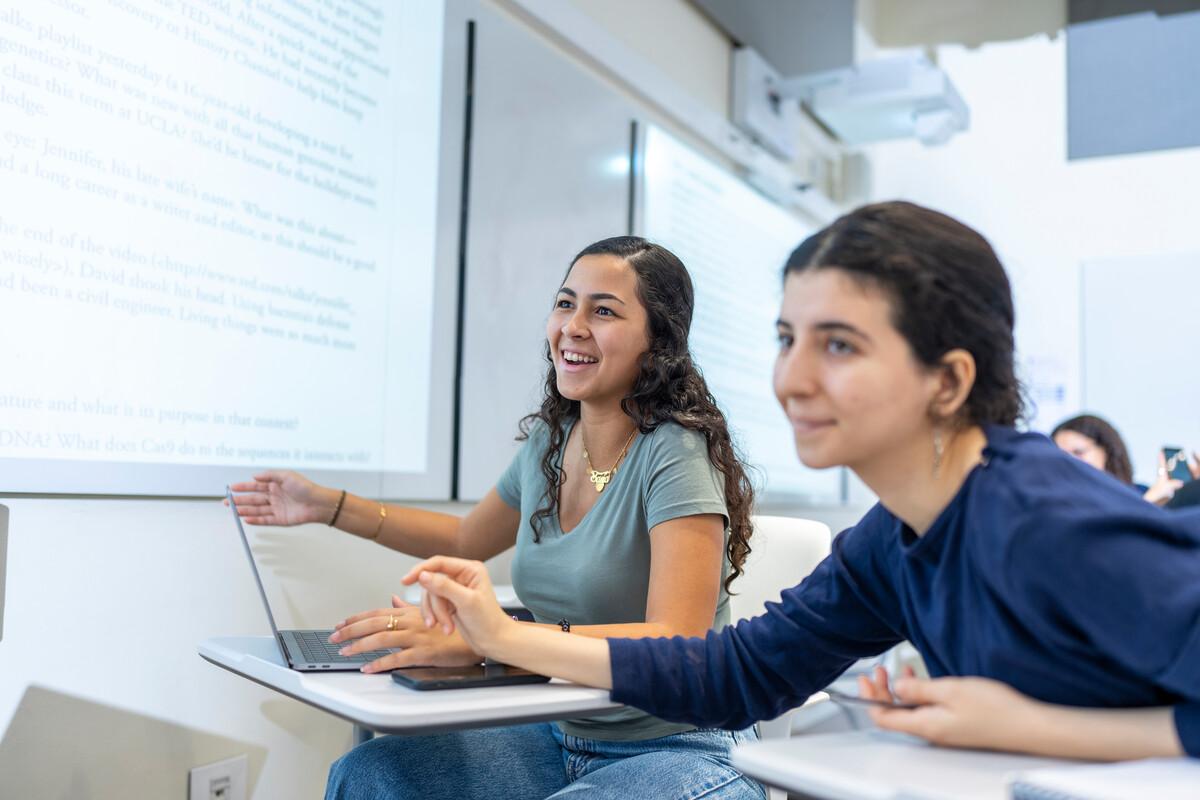 students in classroom discussing topics on smart board