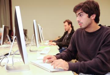 male student working on mac computer 