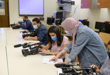 students in class learning how to use cameras