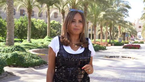 A woman is standing in a garden area