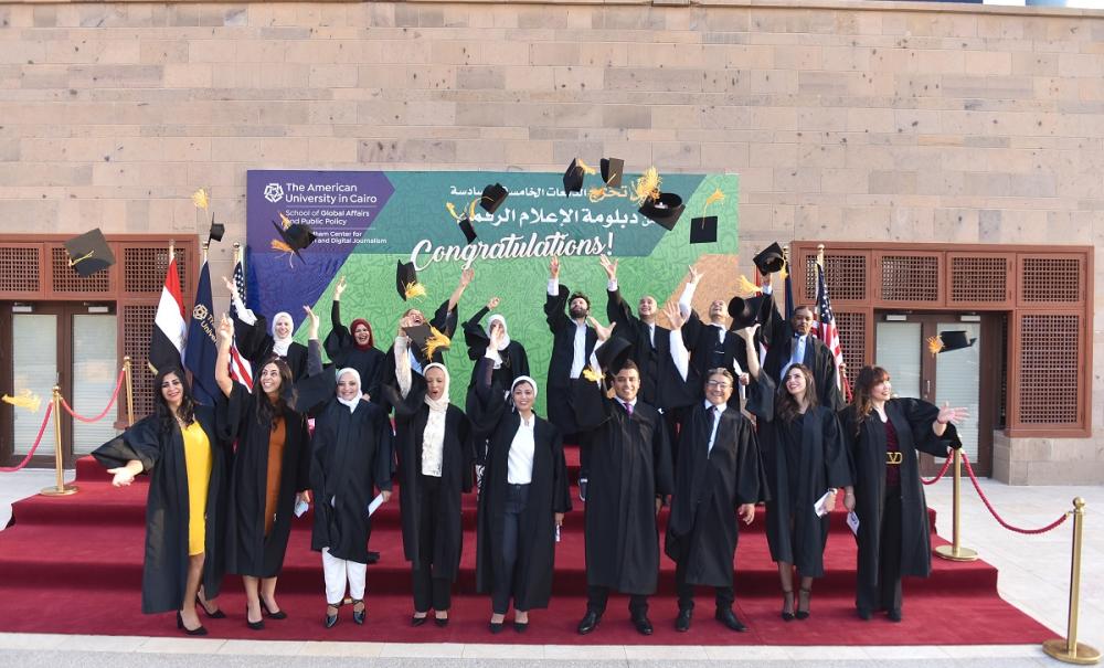 Graduates throwing their caps in the air, text reads "حفل تخرج الدفعات الخامسة والسادسة من دبلومة الإعلام الرقميو Congratulations, The American University in Cairo, School of Global Affairs and Public Policy, Kamal Adham Center for Television and Digital Journalisml