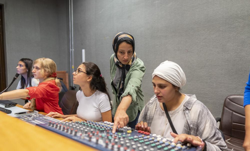 faculty showing students how to use studio equipment for filming 