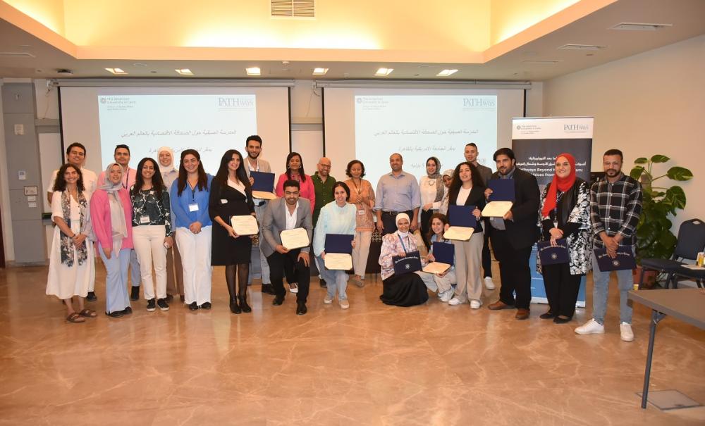 Males and females are standing together and smiling. Some of them are holding certificates