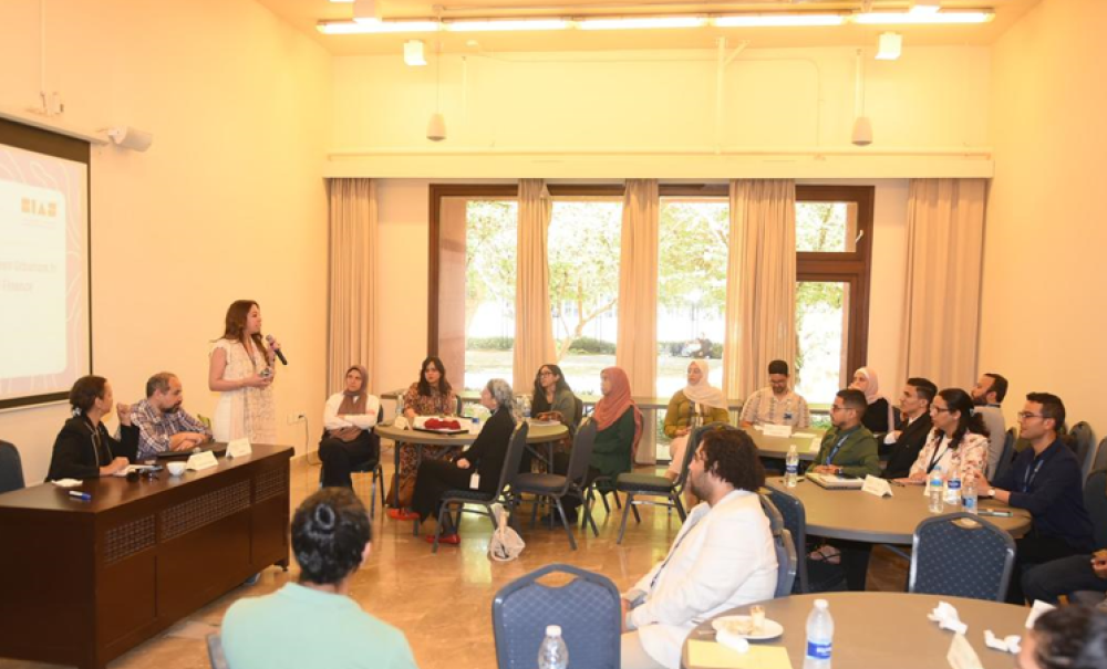 A woman is talking into a microphone in a class full of people