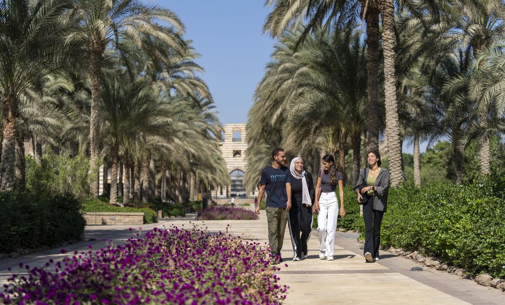 group of students walking in the auc gardens