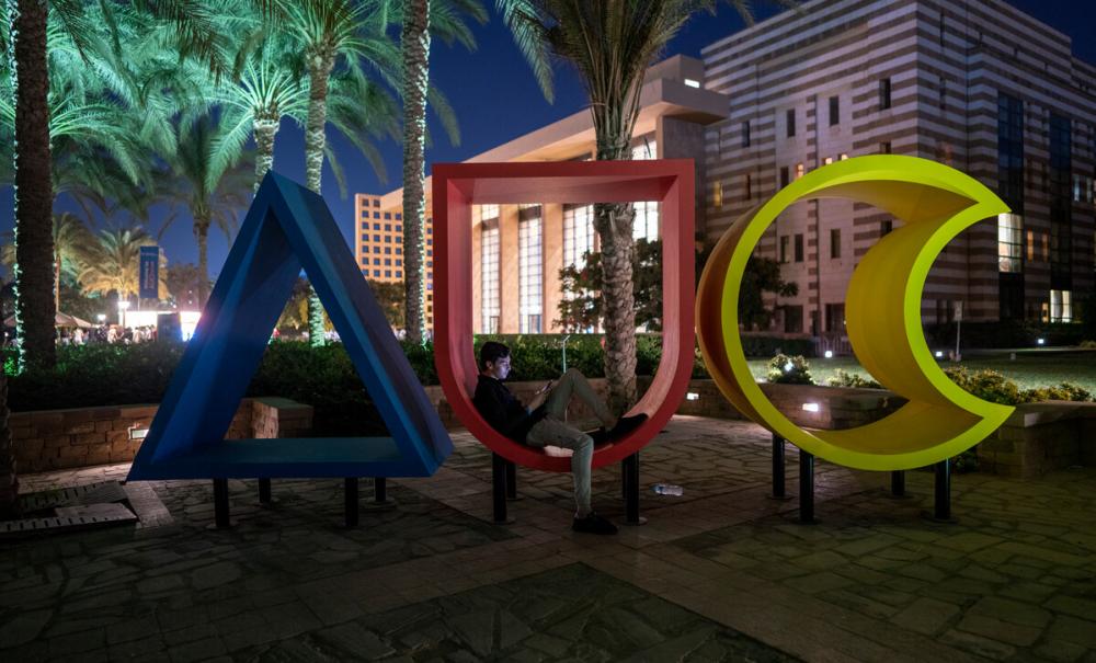 AUC logo in the garden at night