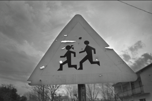 A street sign that has icons of a boy and a girl running