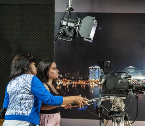 professor working with student in studio and how to work filming camera