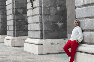 a woman leaning on a museum wall