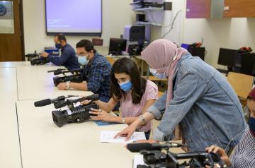students in class learning how to use cameras