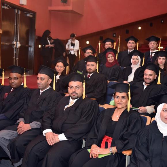 Graduates wearing their caps and gowns and sitting in a theatre 