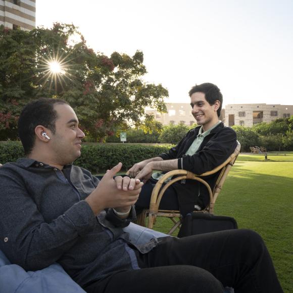 students sitting and chatting in the auc new cairo gardens