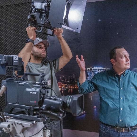 student working with instructor on using camera equipment in studio