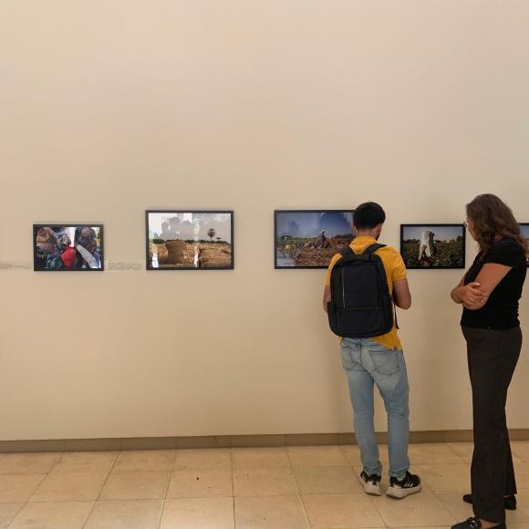 students checking photos on the wall at photo gallery exhibition