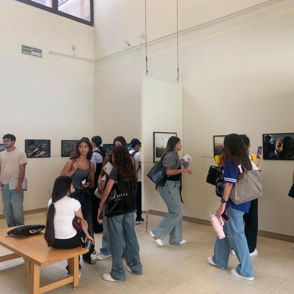 students checking photos on the wall at photo gallery exhibition