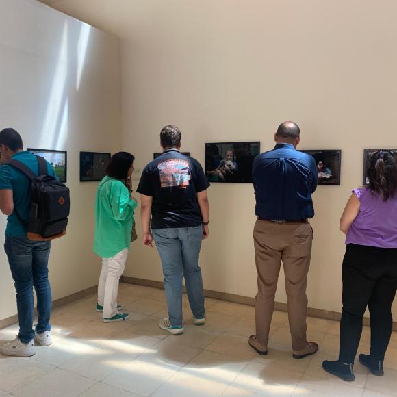 students checking photos on the wall at photo gallery exhibition