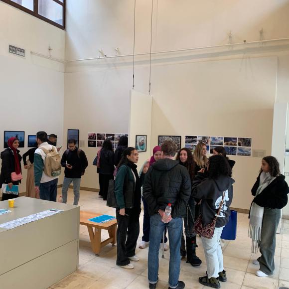 students checking photos on the wall at photo gallery exhibition