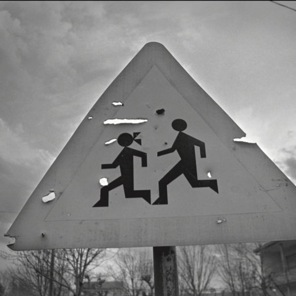 A street sign that has icons of a boy and a girl running