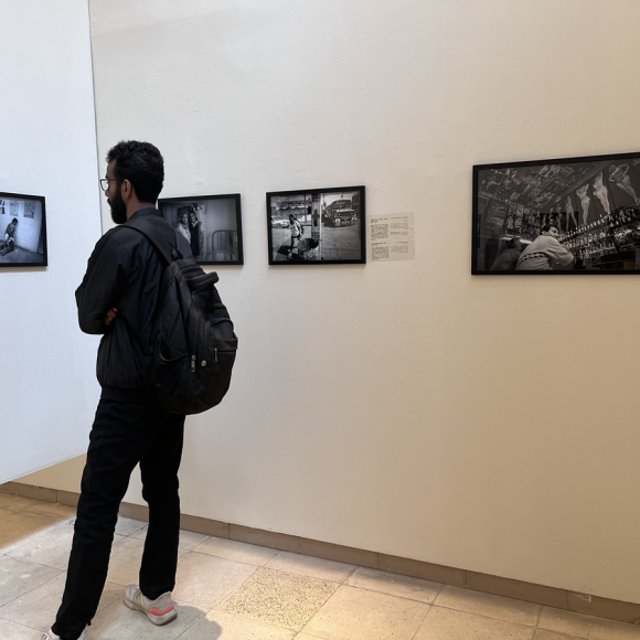 A man  looking at photographs displayed at an exhibition