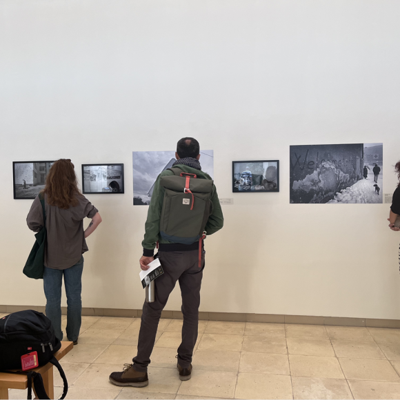 People looking at photographs displayed at an exhibition